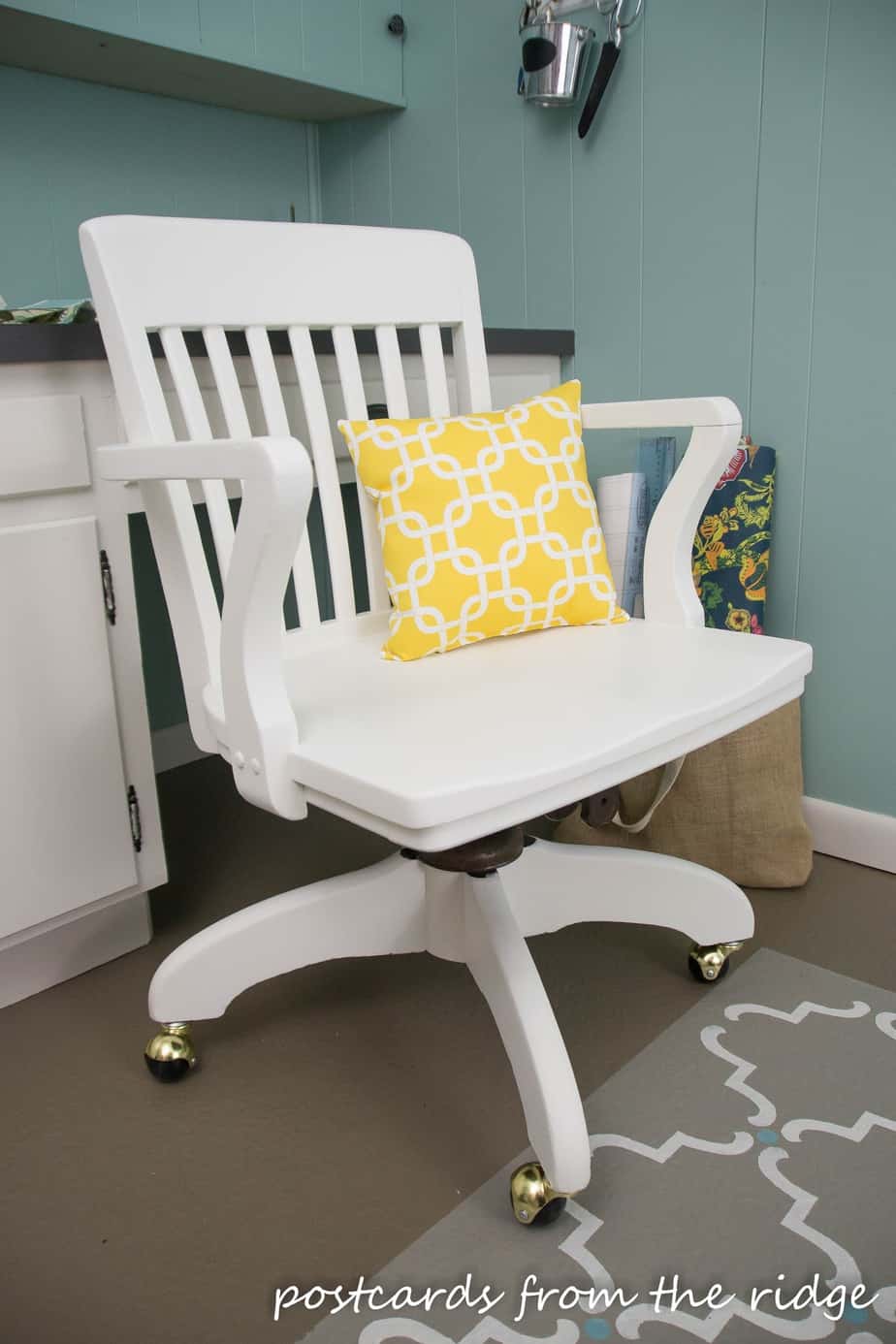 New wheels, a new pillow, and a fresh coat of white dove paint give this wooden swivel office chair a new lease on life.