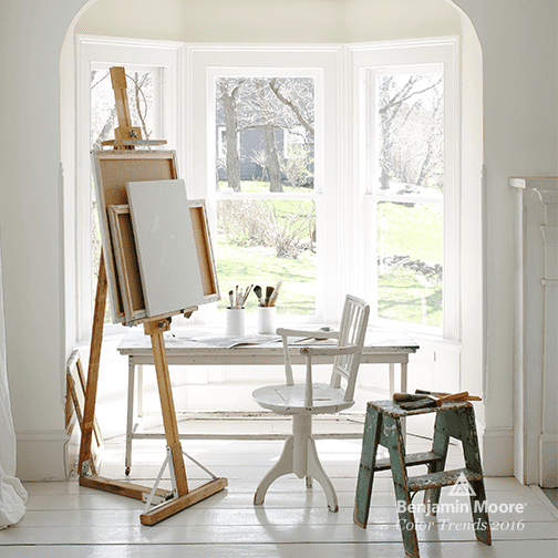 studio with simply white walls and wood art easel