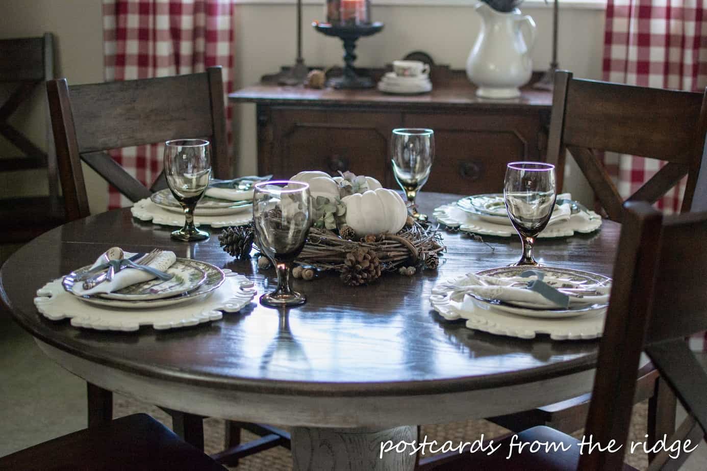 Vintage silverware and linens paired with brown transferware. And a nice centerpiece using natural items.