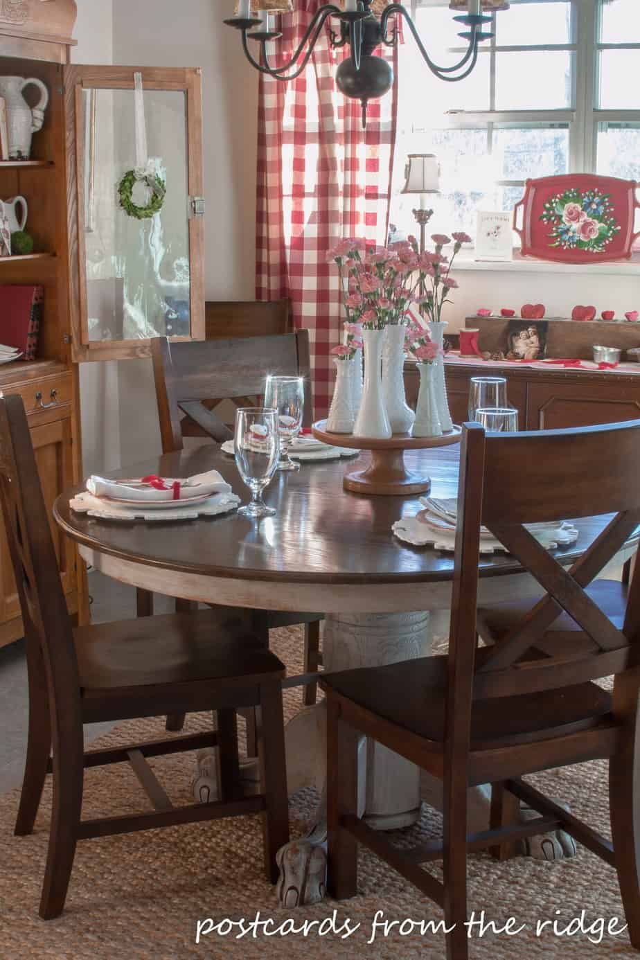 French farmhouse style dining area with buffalo check curtains, milk glass, ironstone, and more.
