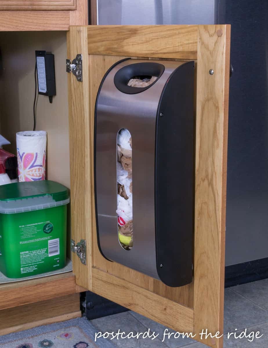 plastic grocery bag organizer mounted to cabinet door