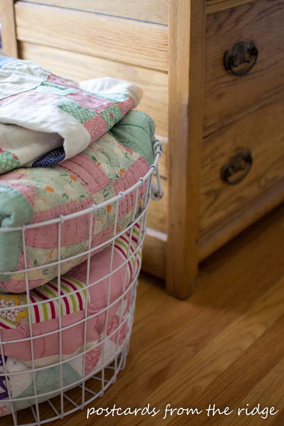 Pretty vintage quilts in a basket. So many great decorating ideas here. Postcards from the Ridge