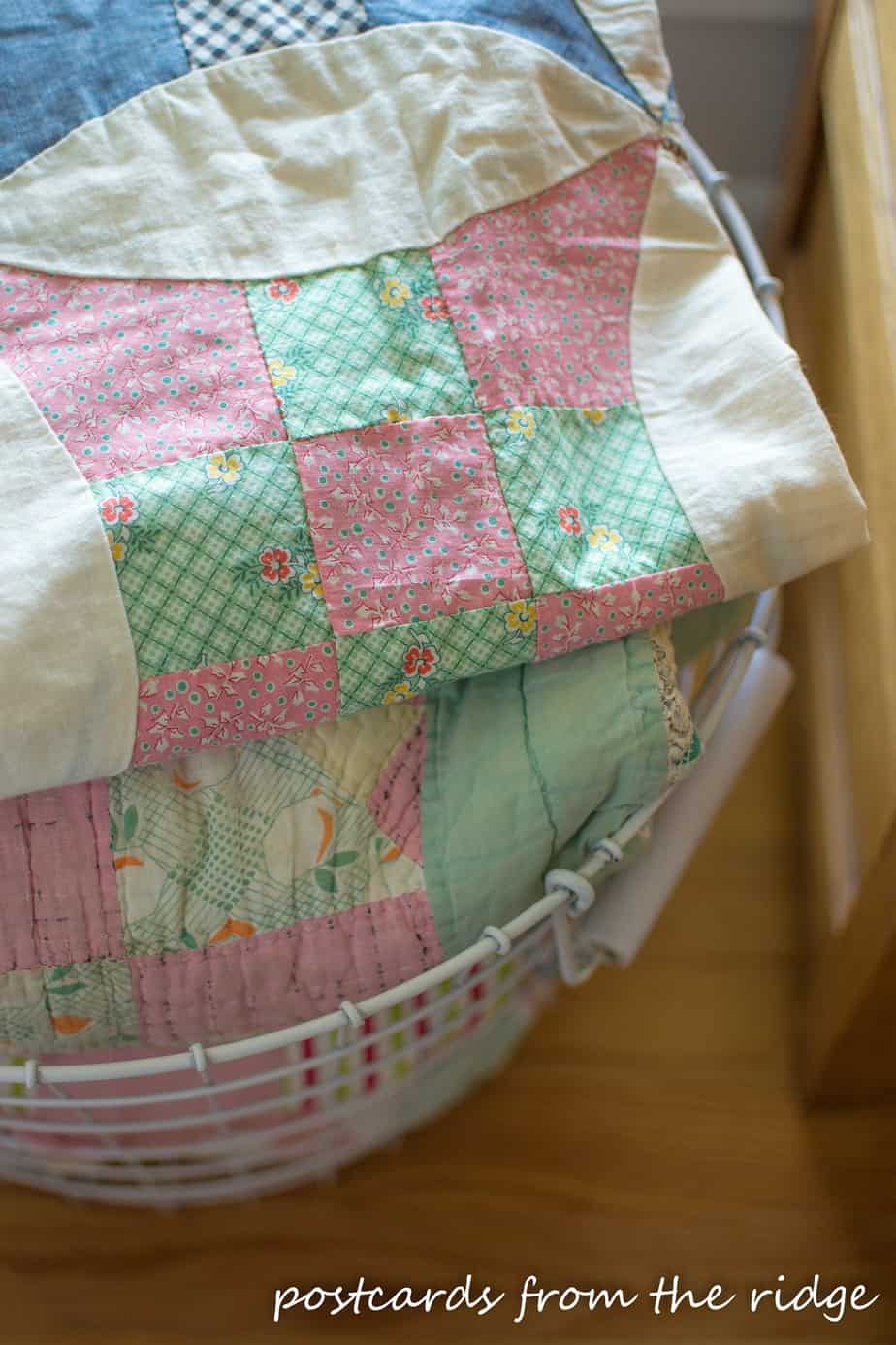 Beautiful old quilts in a basket for decor. Lots of other great ideas on this site. Postcards from the Ridge.