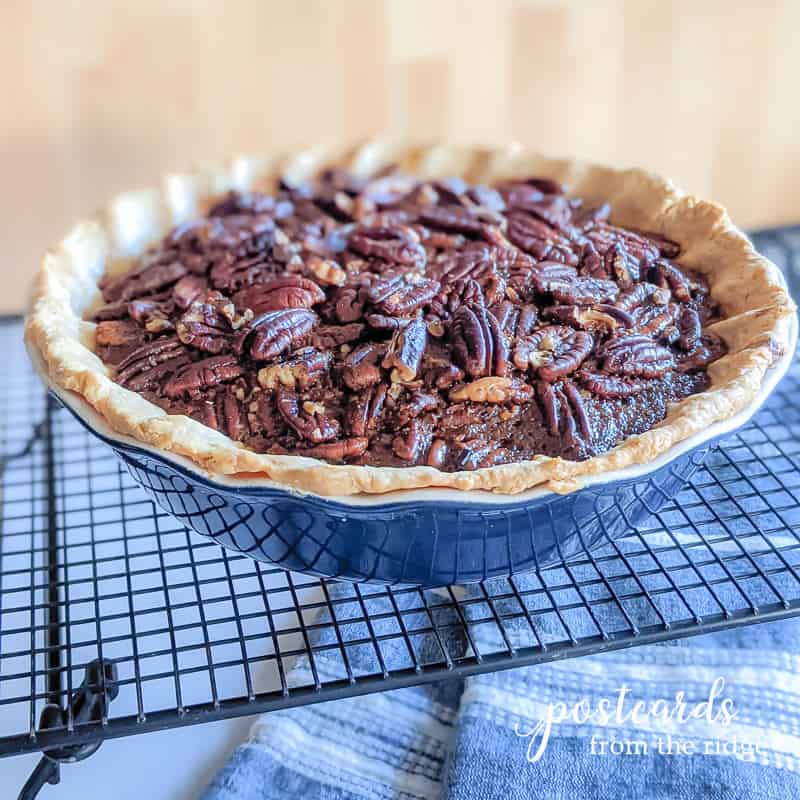 salted caramel pecan pie in blue stoneware pie dish