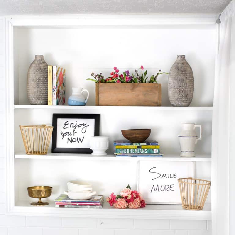 pretty decor in white bookcases 