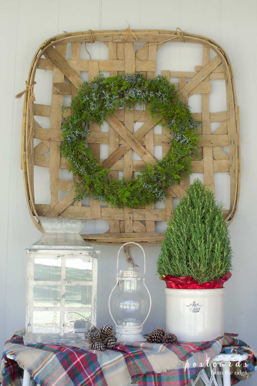 vintage tobacco basket with fresh wreath and candle lanterns for Christmas porch decor