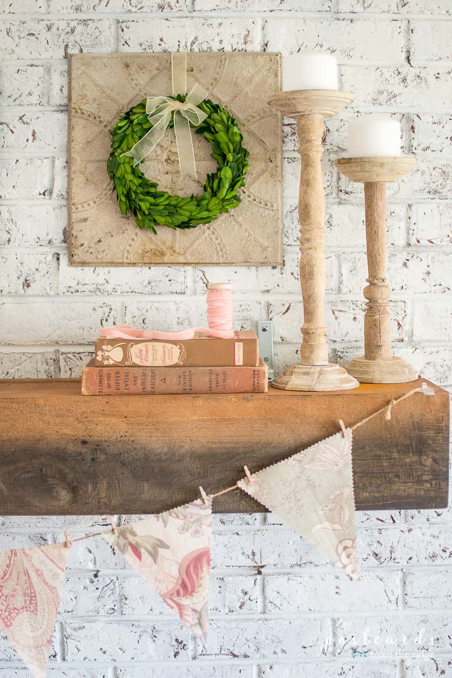 spring mantel with wood candlesticks and fabric banner