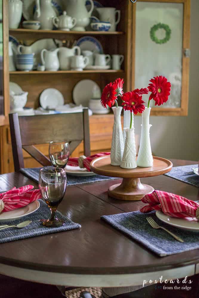 red zinnias in white milk glass vases