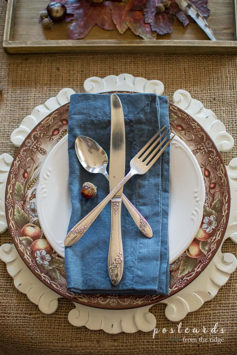 fall table setting with blue napkin and vintage silverware