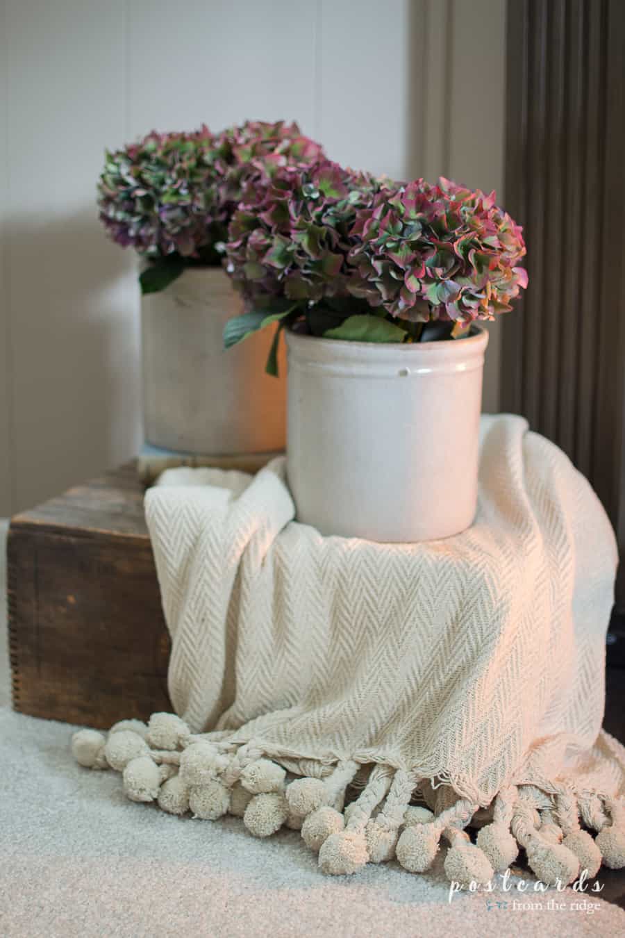 cozy throw blanket with pom poms and hydrangeas
