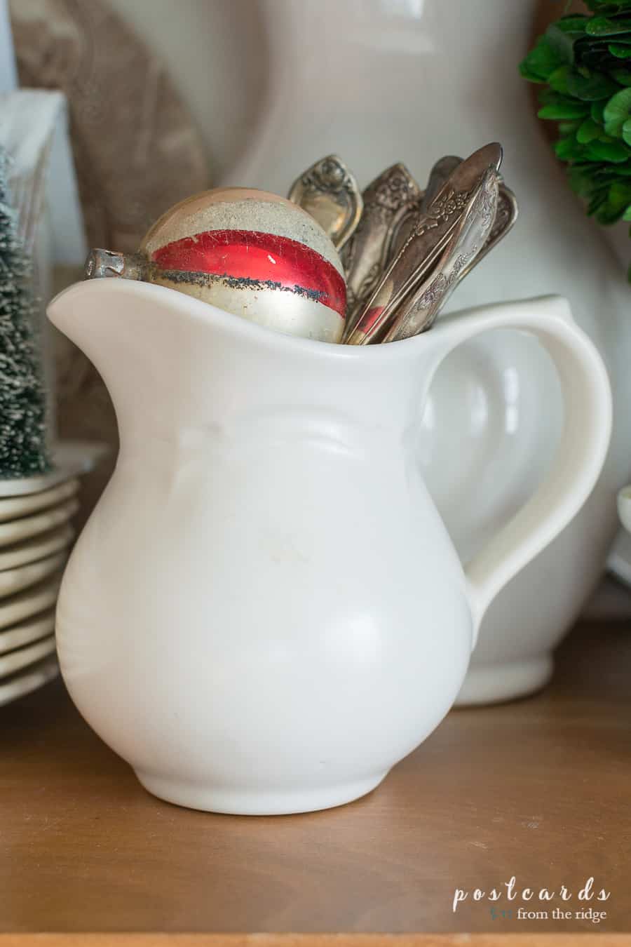 little white creamer and vintage Christmas ornaments
