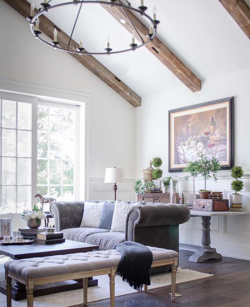 light living room with tufted sofa and wood beams
