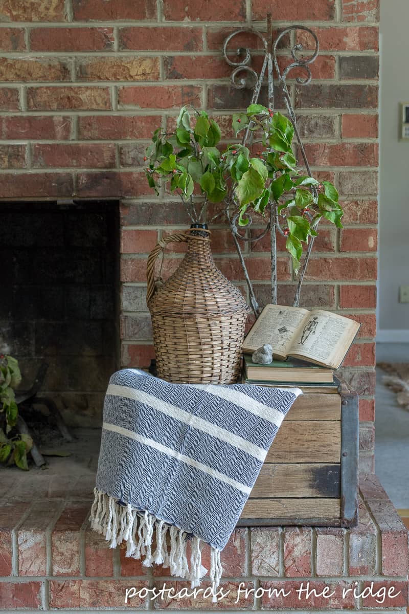 striped throw blanket and wicker demijohn on old wooden milk crate
