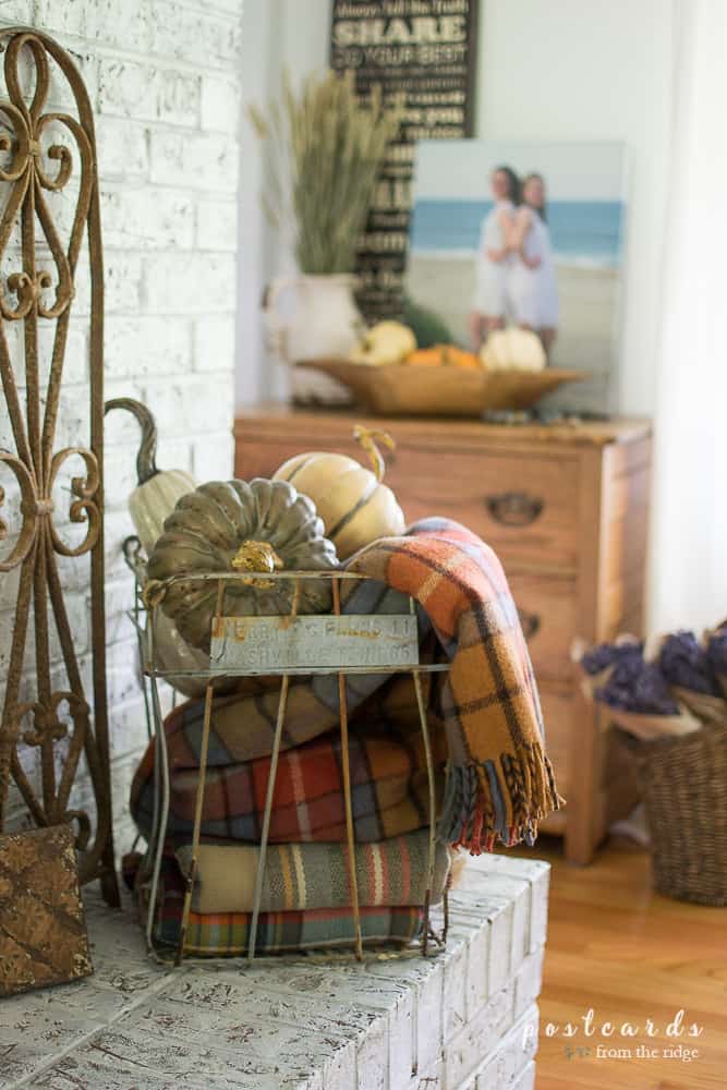 vintage wire egg crate with faux pumpkins and plaid throw blankets