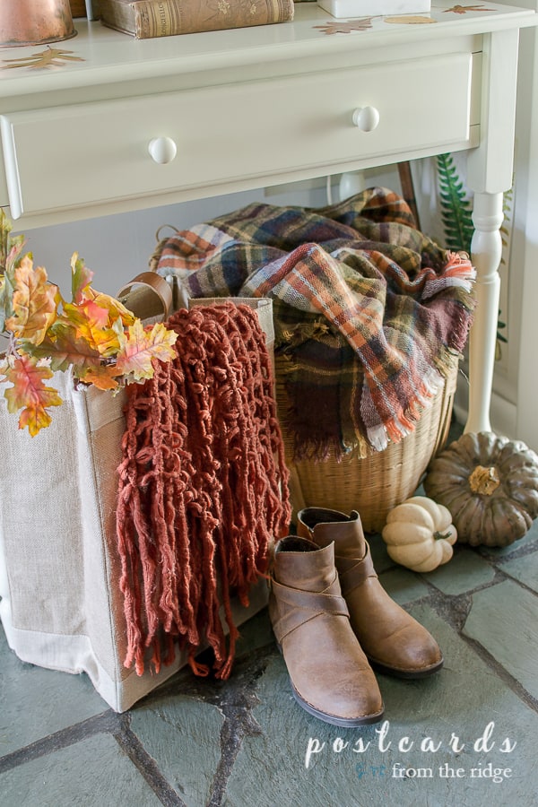boots, bag with rust scarf, faux pumpkins on slate floor