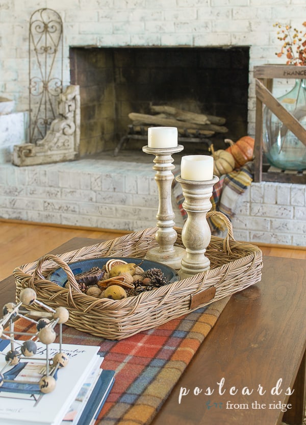 tall wood candleholders in basket on wood table