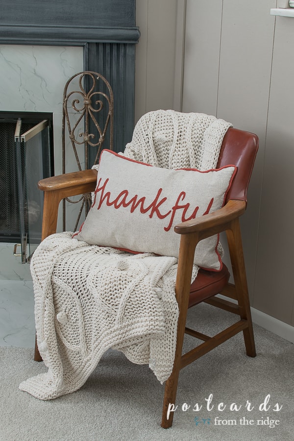 thankful pillow and cream throw blanket on mid century modern arm chair