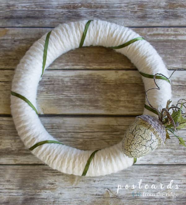 white sweater wreath with green ribbon and acorn ornament