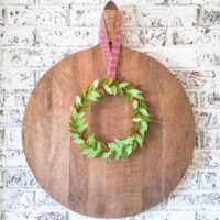felt wreath hanging on round wooden board