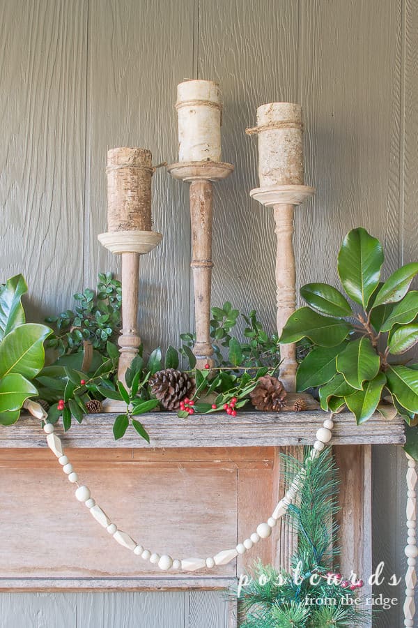 outdoor Christmas mantel with rustic wood candlesticks and birch pillar candles
