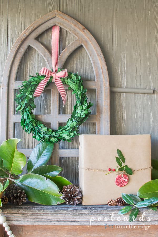 arched wooden cathedral window frame with preserved boxwood wreath and red striped ribbon