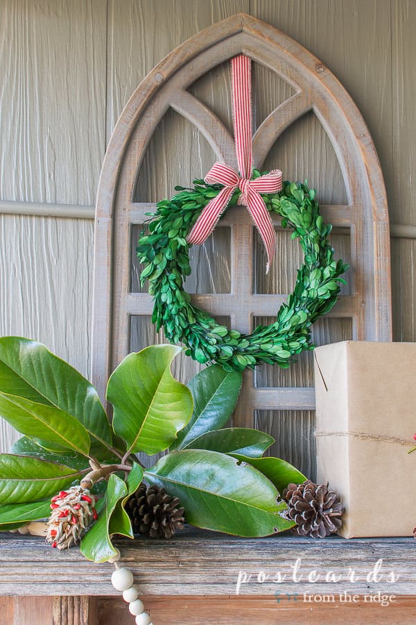 preserved boxwood wreath and magnolia leaves with wood cathedral window frame