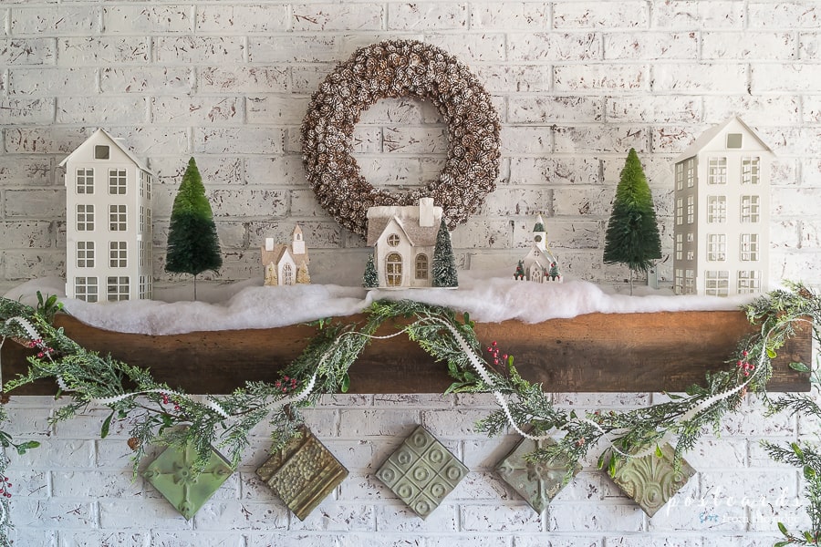 Christmas mantel with little white houses and bottle brush trees