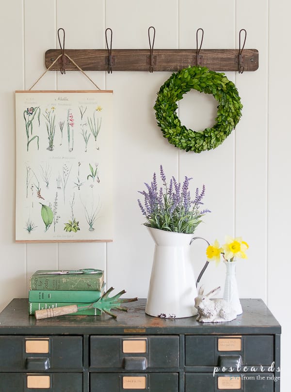 spring decor including faux flowers, boxwood wreath, and botanical art