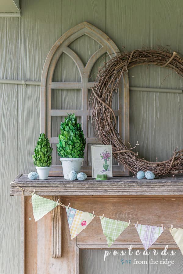 fabric banner and spring decor on rustic mantel