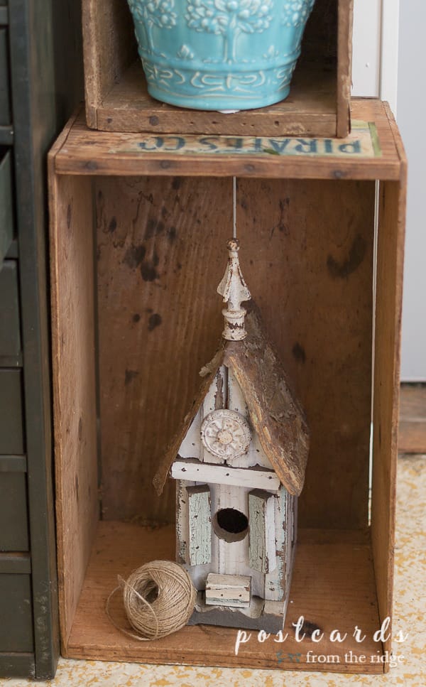 rustic birdhouse in old wooden crate used as cottage garden decor