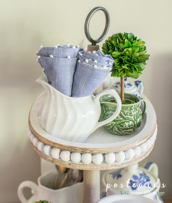 blue and white vintage and thrifted items in a wooden tiered tray