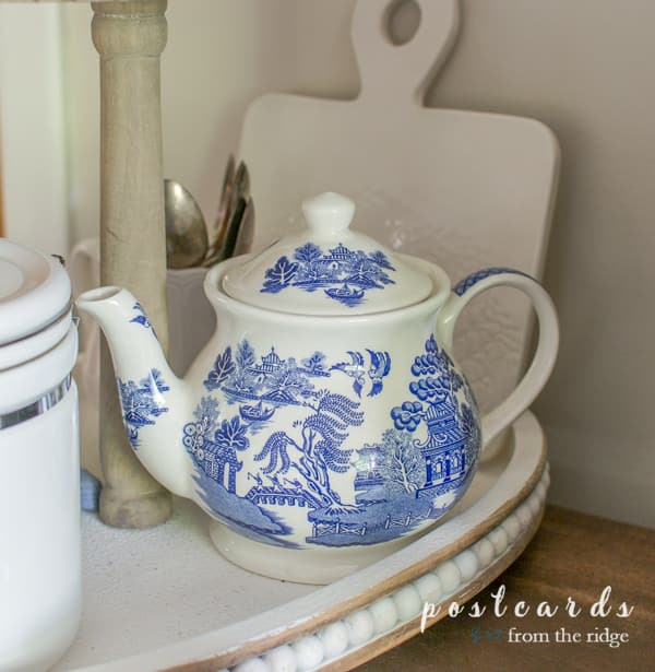 blue and white vintage teapot and thrifted items in a wooden tiered tray