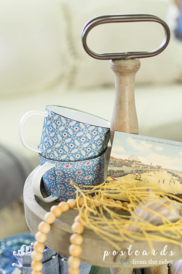 blue and white enamel mugs on a wood tiered tray