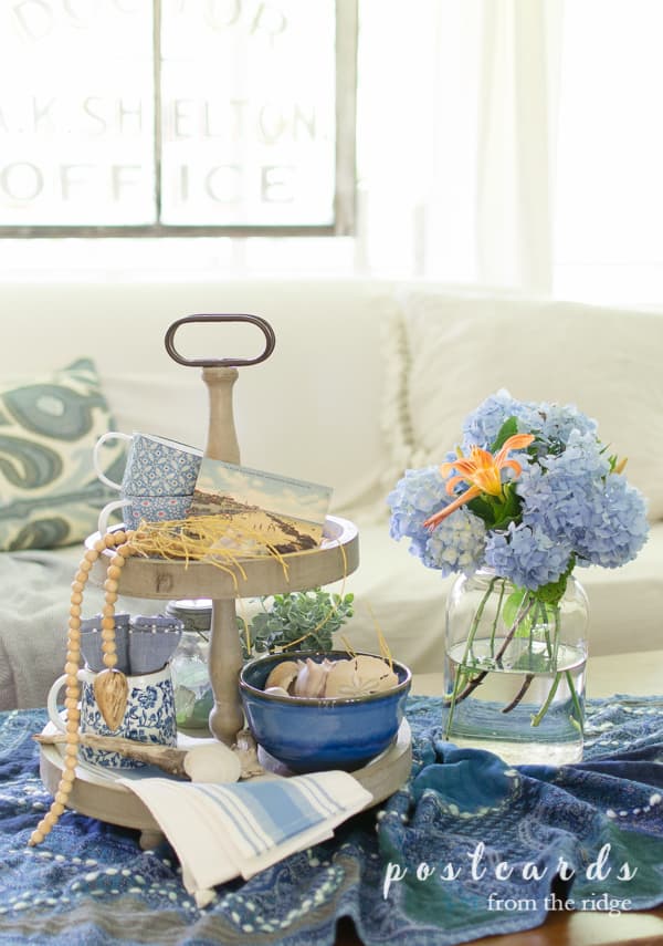 blue hydrangeas in a mason jar with blue and white decorated tiered tray