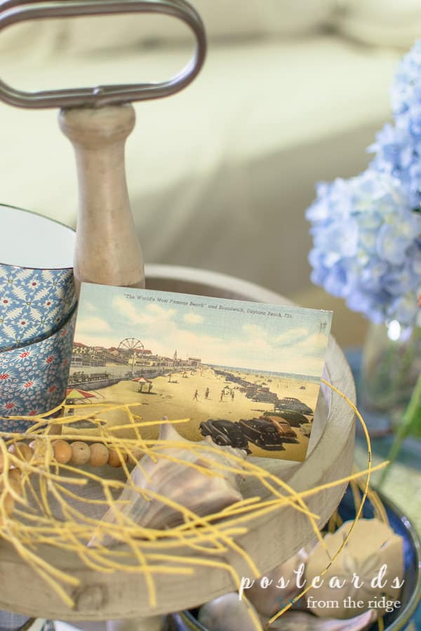 vintage Daytona Beach postcard and coastal decor on a wood tiered tray