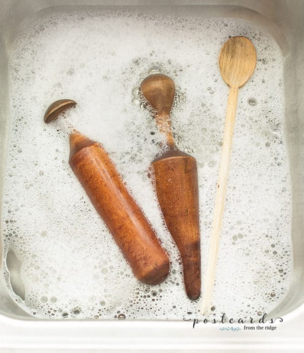 vintage wooden utensils in warm soapy water