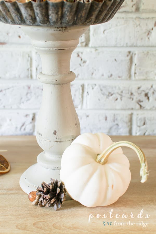 little white pumpkin and pine cone with diy pedestal stand made with wooden candleholders and tart pans
