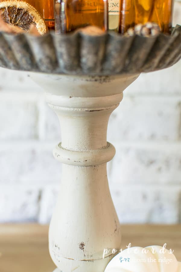 distressed paint finish on diy pedestal stands made from wooden candleholders and tart pans
