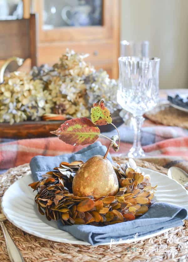 fall table with pears, boxwood wreath, dried hydrangeas, and thrifted white dishes