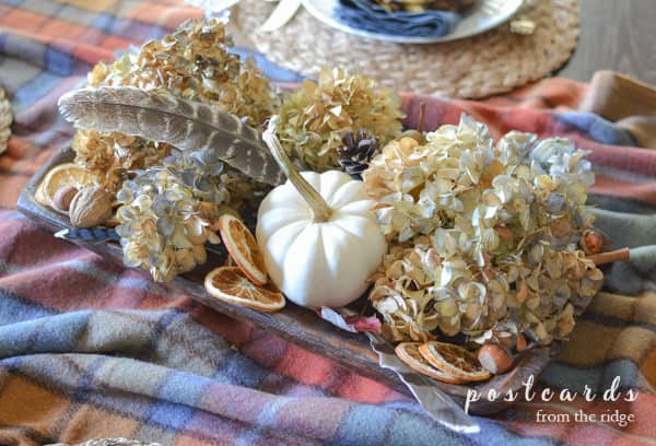 wood dough bowl with dried hydrangeas, dried oranges, nuts, acorns, feathers