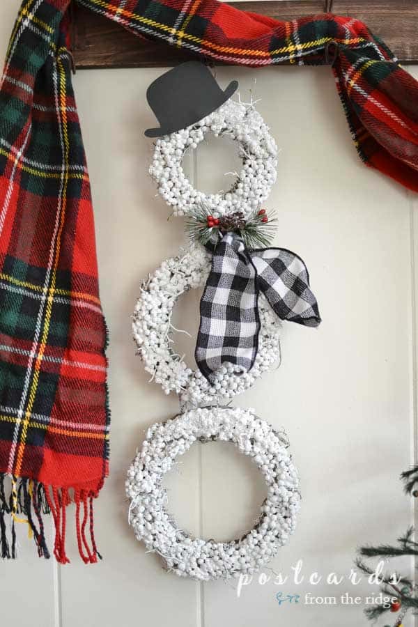 snowman wreath with buffalo check scarf and black paper hat