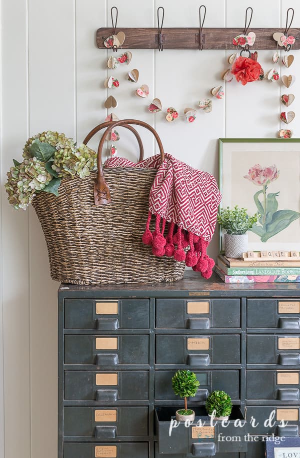 vintage metal cabinet with woven basket and valentine's day decor