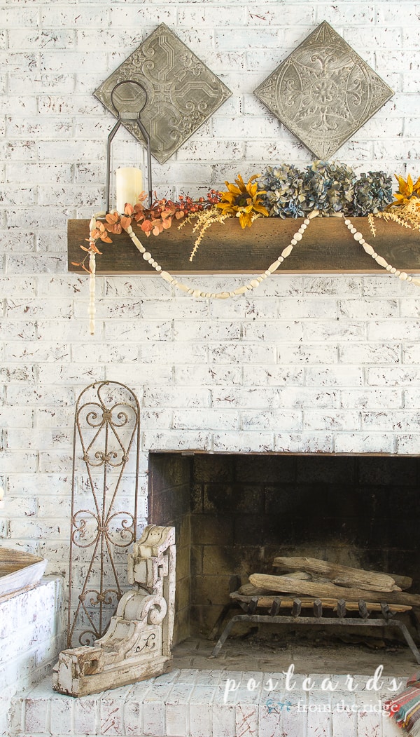 salvaged antique wooden corbel and fence section on white fireplace