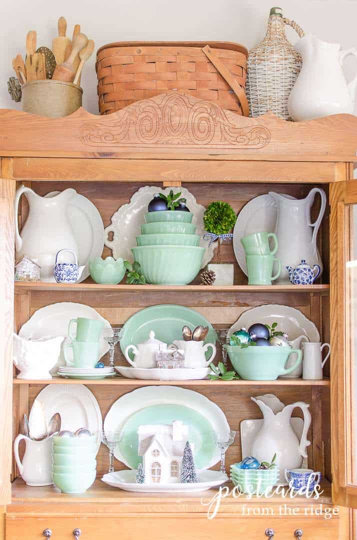 antique oak hutch with vintage jadeite pieces, white ironstone, and blue and white pieces
