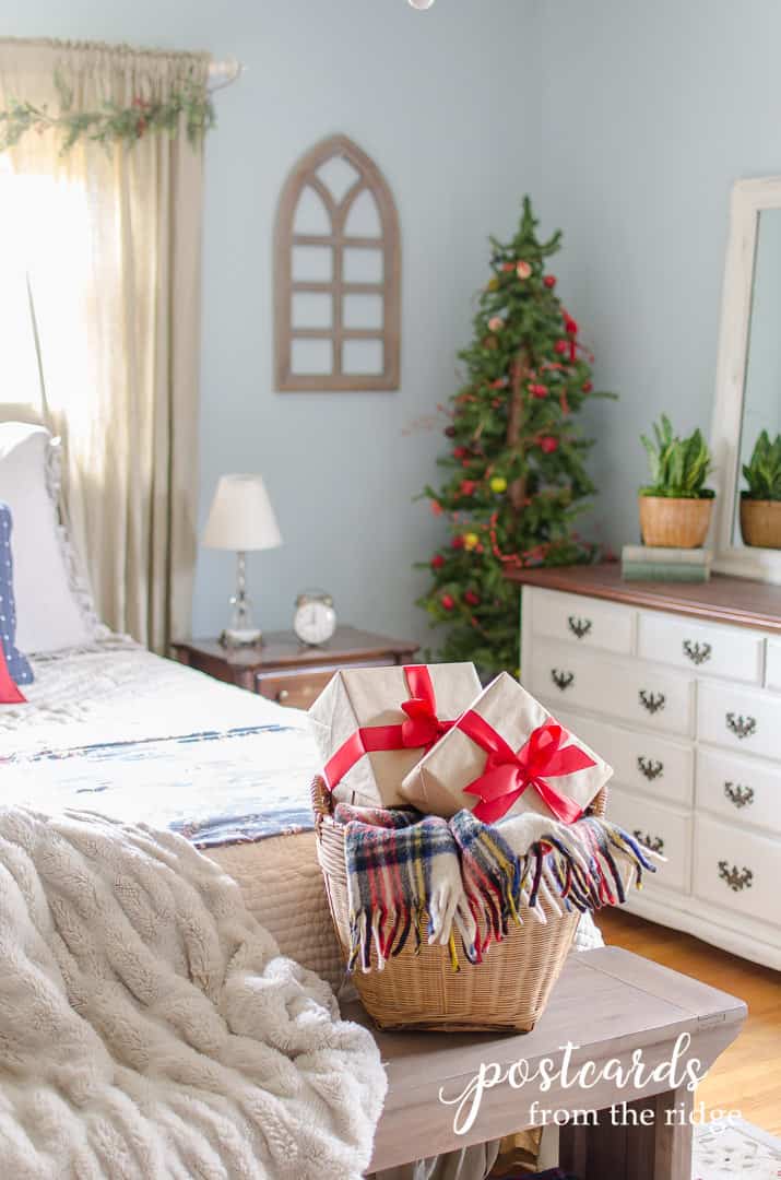 basket with plaid blanker and present with faux fur throw blanket in Christmas bedroom