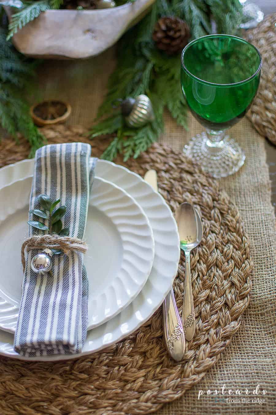 striped napkin tied with twine and embellished with a tiny ornament