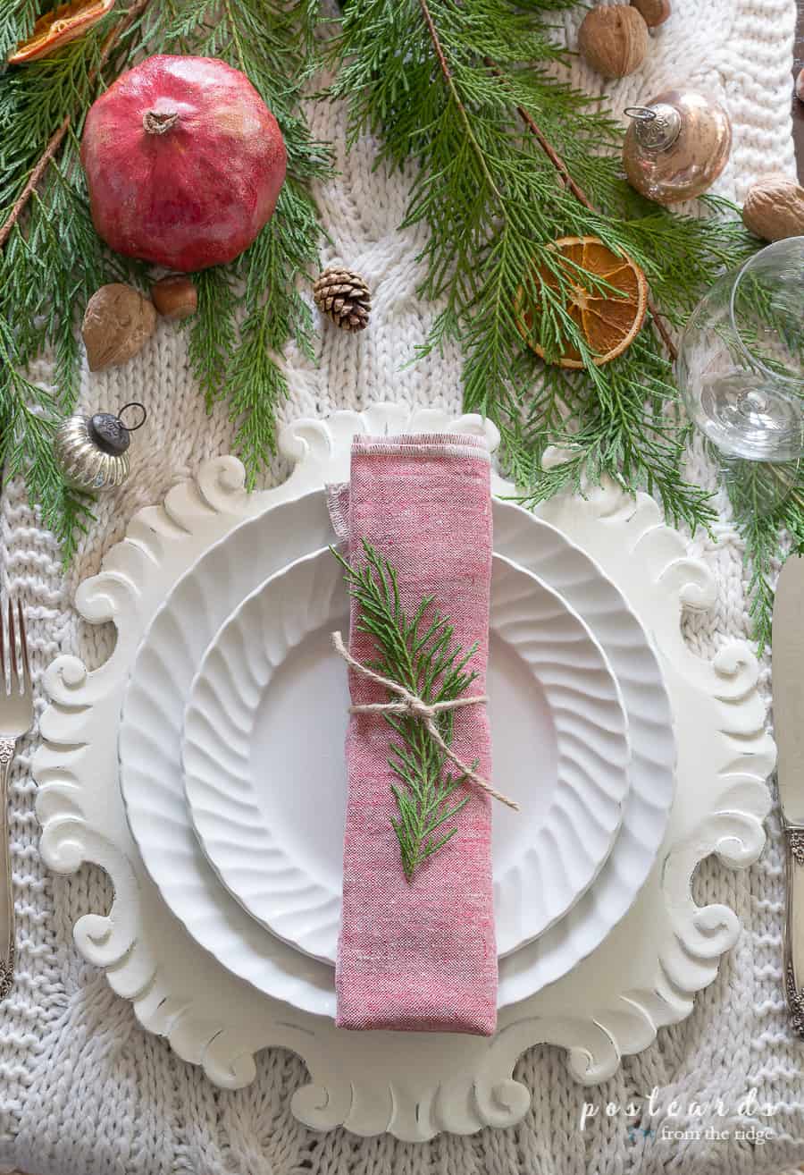 napkin tied with twine and a piece of greenery on a Christmas table