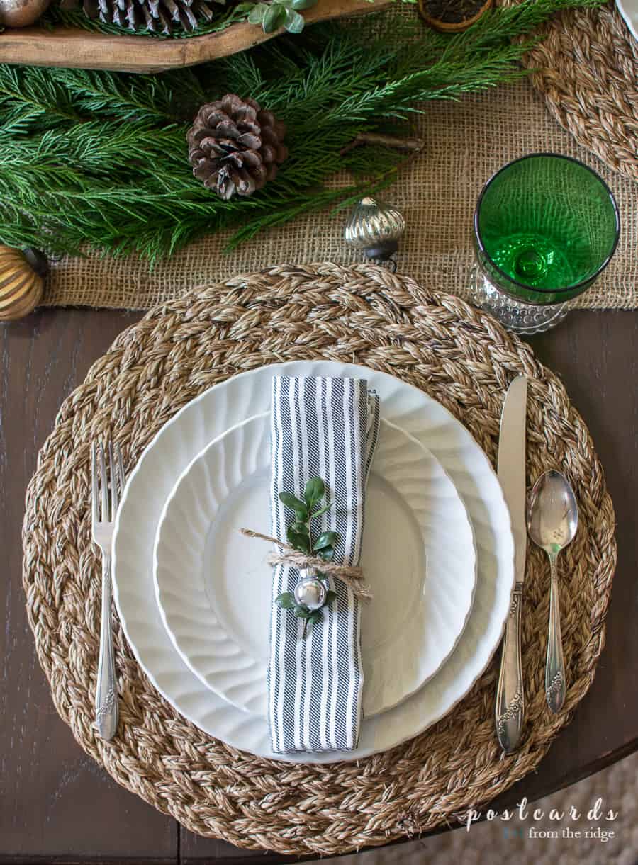 white dishes on woven placemat for Christmas table decorations