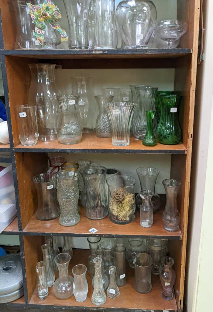 glass vases in wooden bookcase