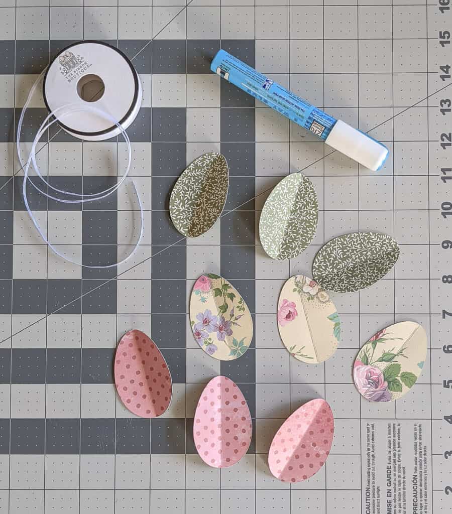 paper egg cutouts with glue pen and ribbon